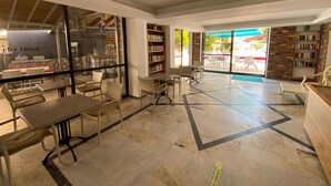 A modern library with bookshelves, tables, and chairs arranged for reading and studying. - Eda Hotel (Marmaris)