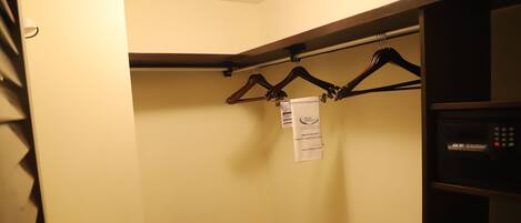 A closet with wooden hangers and a metal drying rack.