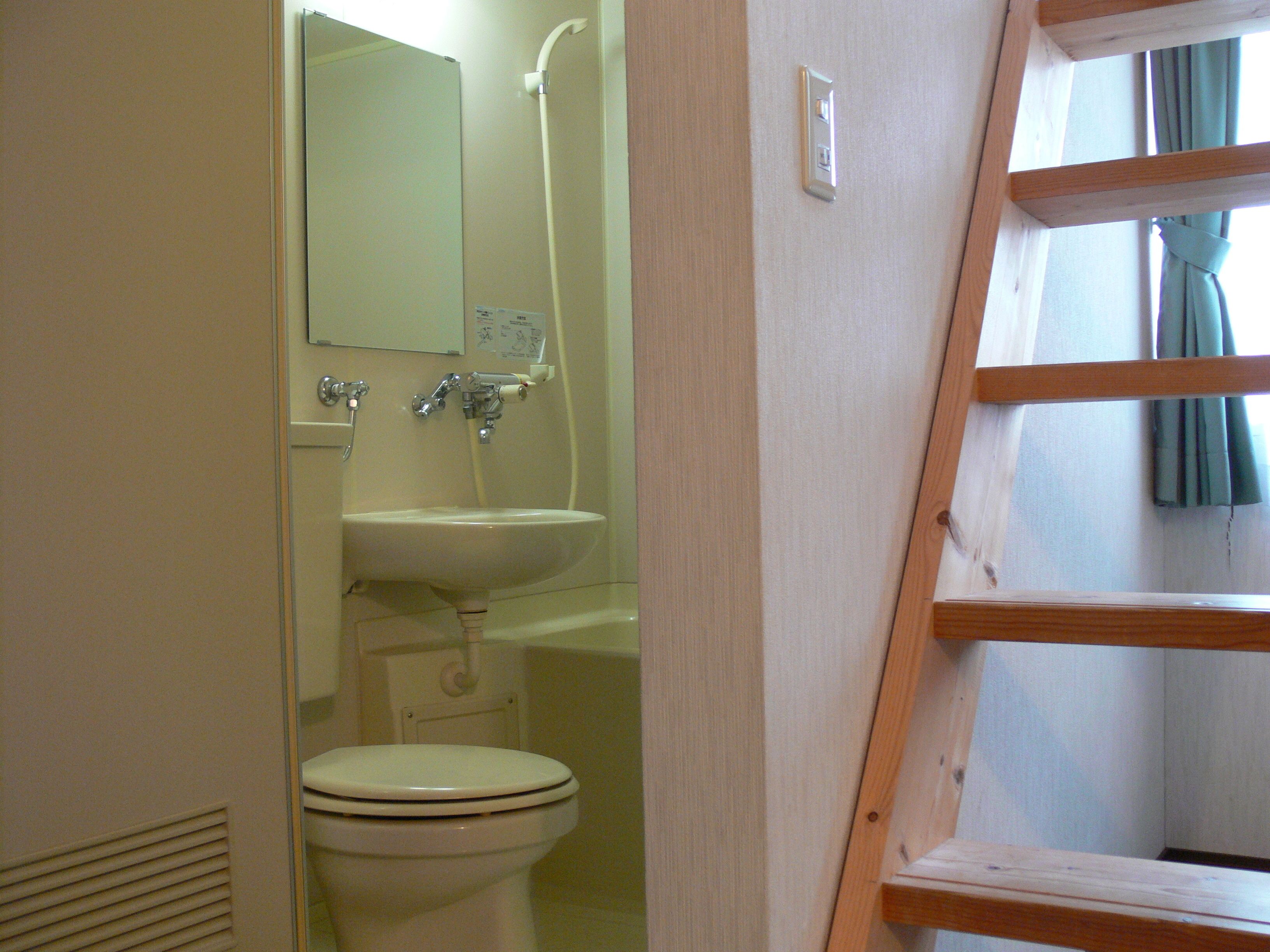 A bathroom with a toilet, sink, and shower.