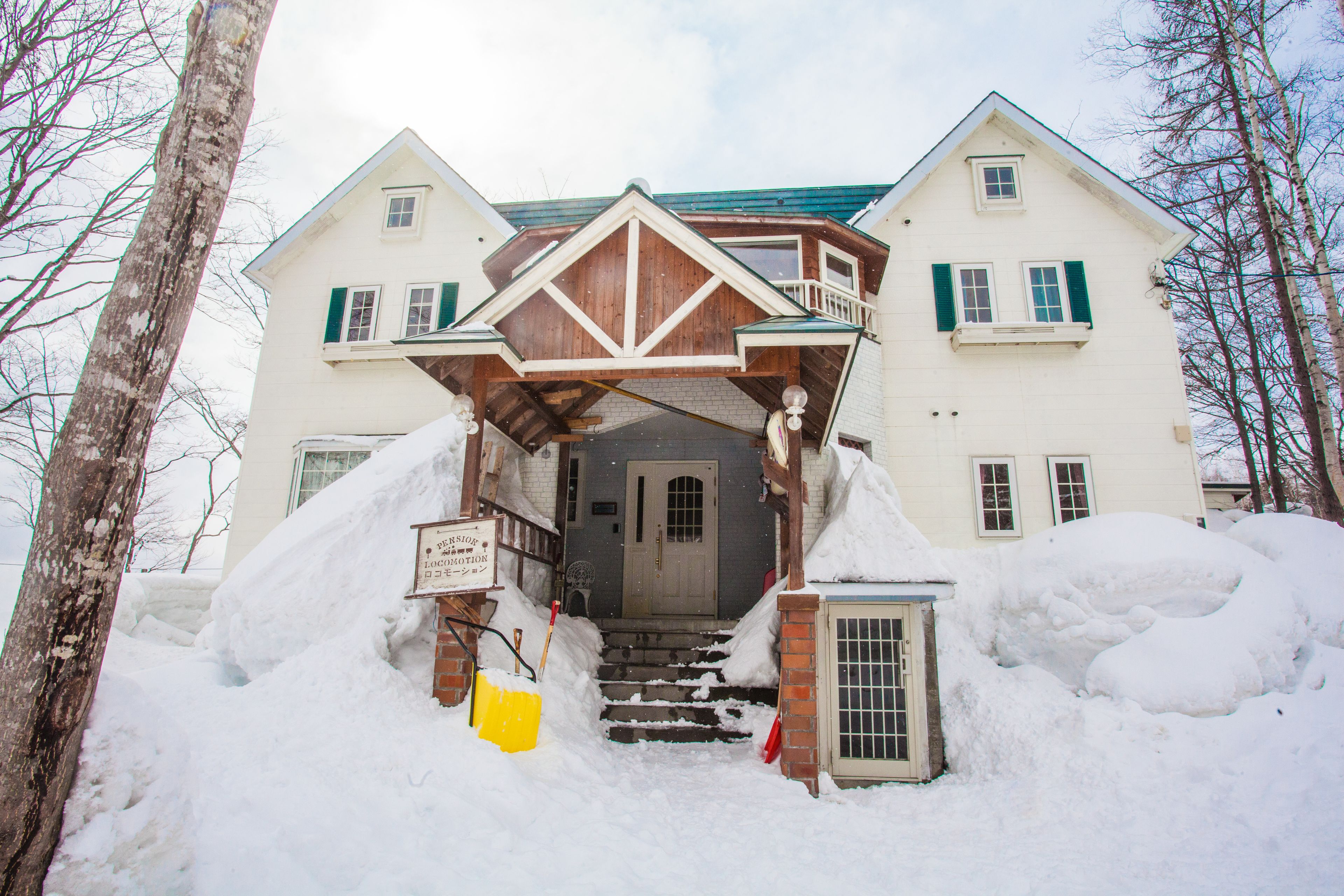 A two-story building with a covered entrance and a snow-covered driveway.