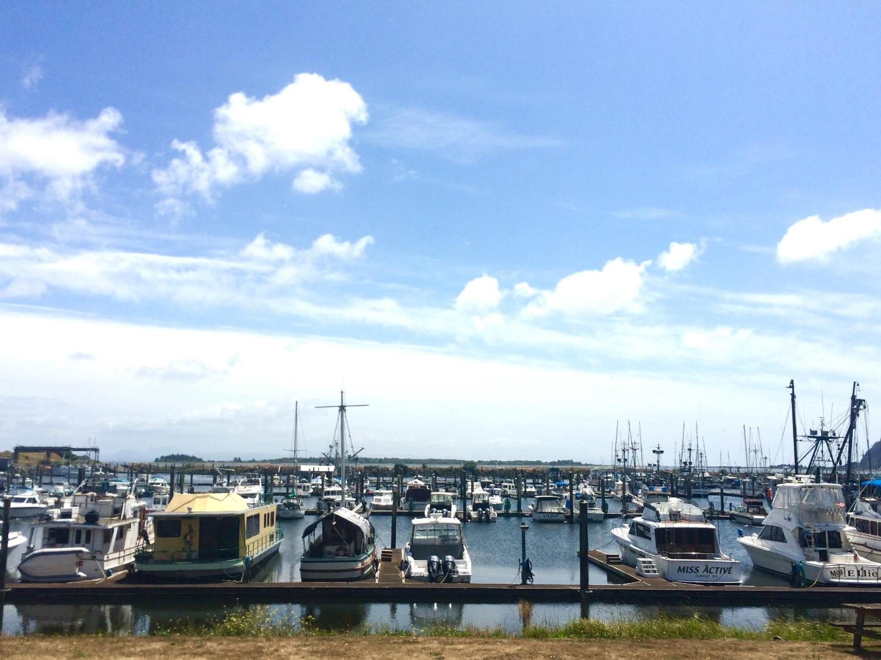 Un port de plaisance où sont amarrés différents types de bateaux, notamment une péniche et un yacht appelé « Miss Active ».