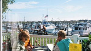 A view from a restaurant with a table and chairs, overlooking a marina with boats. - Salt Hotel & Pub (Ilwaco)