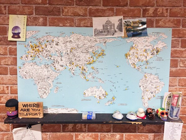 Un mapa mundial con chinelos, un cartel que dice '¿De dónde eres?' y adornos con temática de viajes.