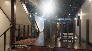 A staircase leading to a higher floor with a sign indicating 'RENTAL SPACE' and 'COMMUNITY SPACE'. - Omotenashi LAB - Hostel (Sakura)