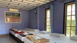 A room with four beds, each with neatly folded towels and blankets. - Ruenview Resort (Mae Chan)