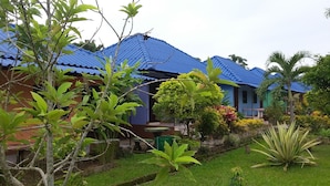 A house with a blue roof, surrounded by lush greenery and a well-maintained garden. - Ruenview Resort (Mae Chan)