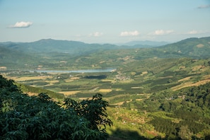 A panoramic view of a mountainous landscape with a lake, surrounded by dense forests and scattered buildings.