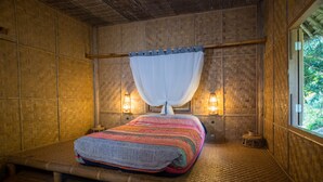 A room with a bed, a window, and two wall-mounted lamps.