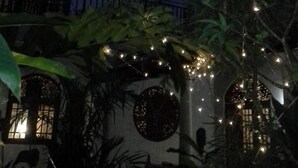 A multi-story building with balconies, surrounded by lush greenery and string lights. - Srimali's Residence (Unawatuna)