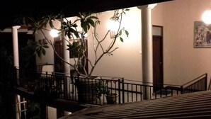 A staircase with a railing, a potted plant, and a wall with a framed picture. - Srimali's Residence (Unawatuna)