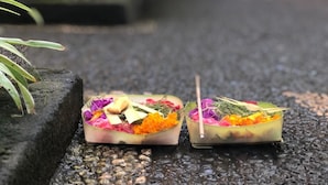Two rectangular containers with colorful flowers and herbs on a textured surface. - Depa House (Ubud)