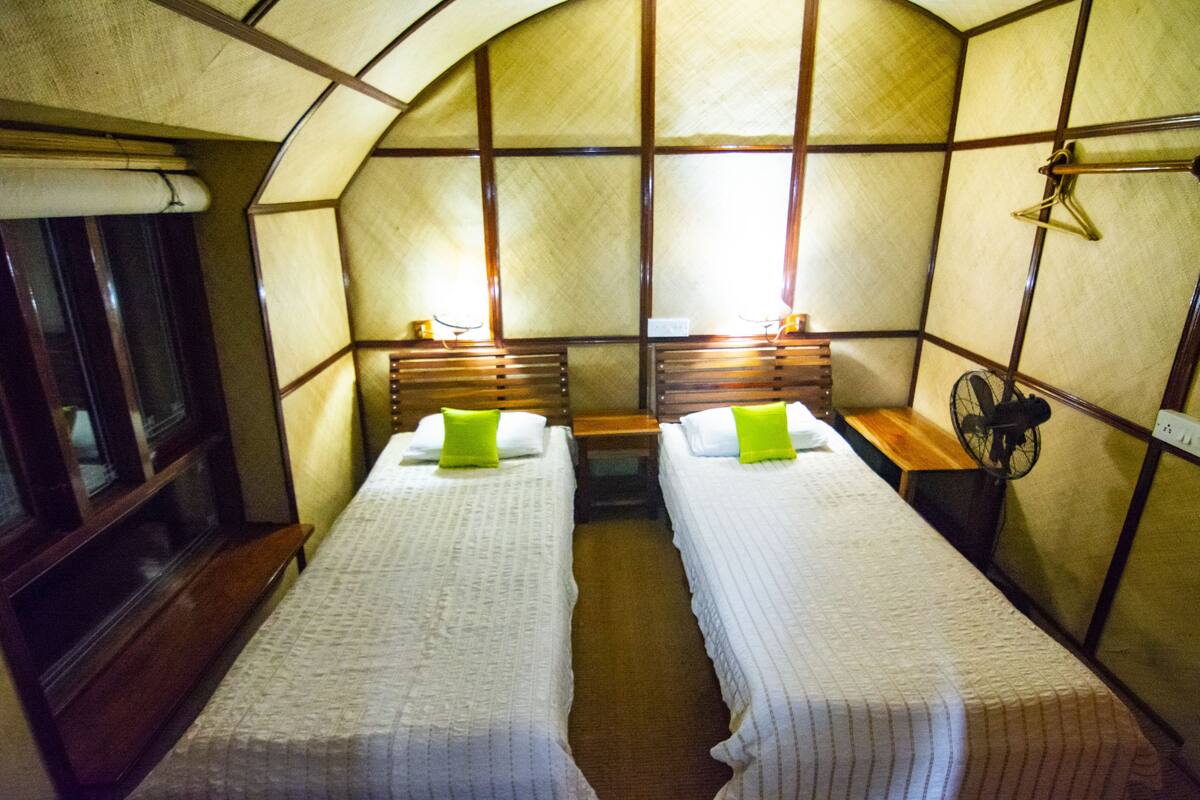 Una habitación con dos camas, cada una con una almohada y una mesita de noche.