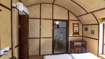 Una habitación con cama, escritorio, silla, lavabo y espejo.