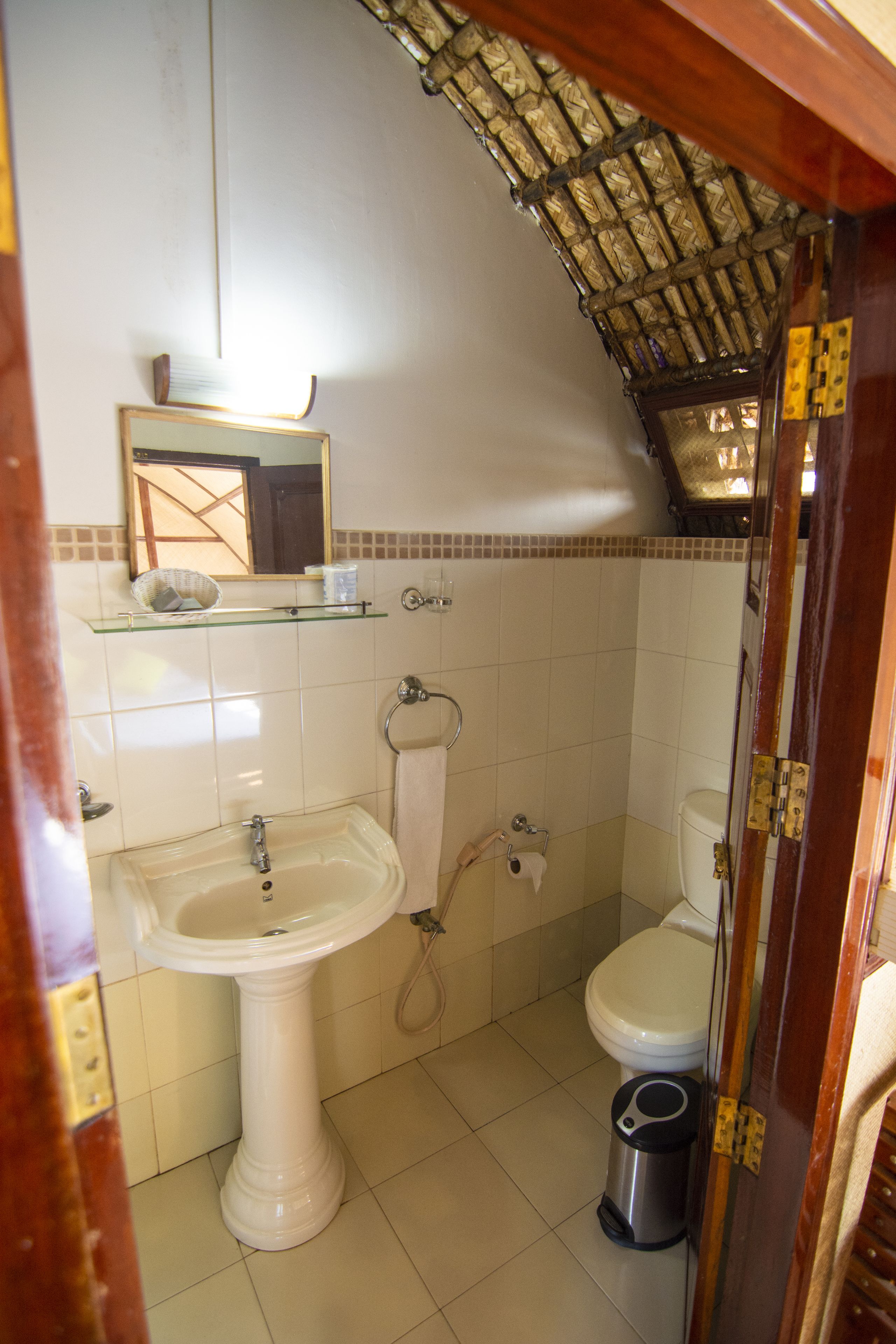 A bathroom with a pedestal sink, toilet, and shower.