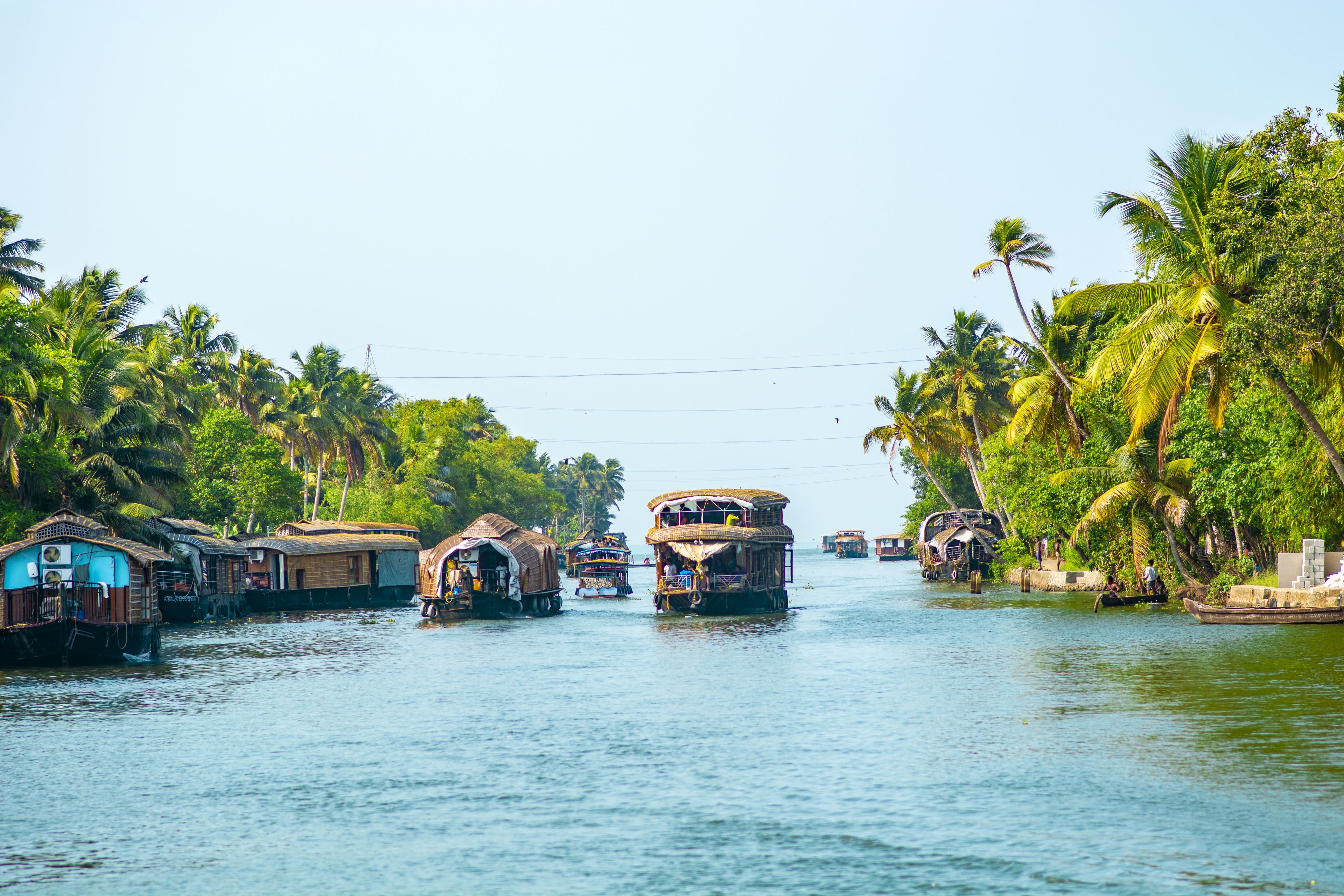Un río con barcas tradicionales y casas a orillas.