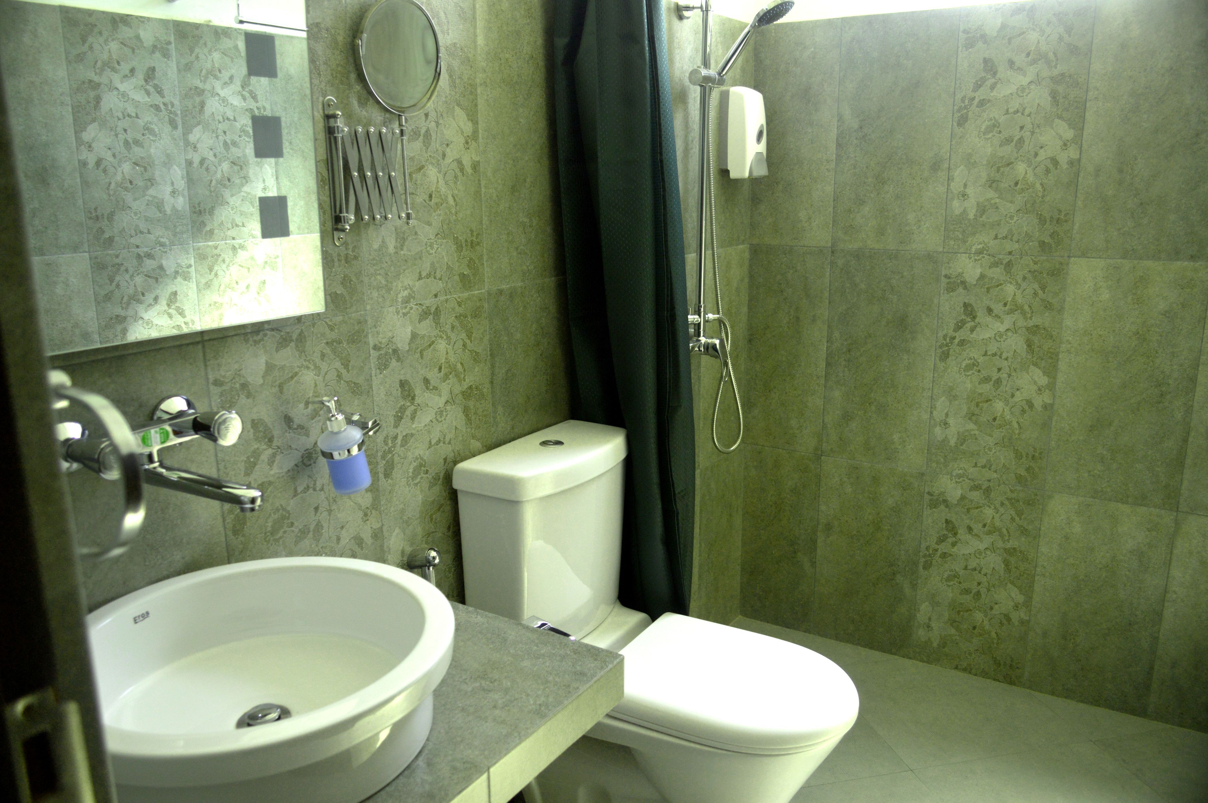 A bathroom with a sink, toilet, and shower.