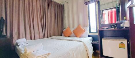 Ein Hotelzimmer mit Bett, Kissen, Schreibtisch und Spiegel.