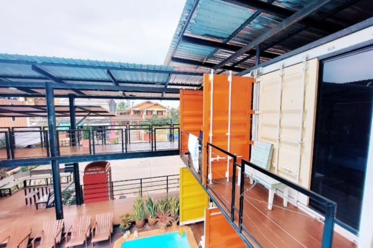 Una terraza al aire libre con varios niveles, mobiliario de madera y una piscina pequeña.