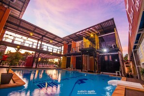 An indoor swimming pool with a covered area and a glass enclosure. - Retro Box Hotel (Chumphon)