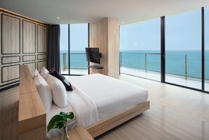 Un dormitorio moderno con una cama grande, televisión y vista al océano.