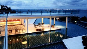 Un hôtel moderne doté d’une piscine sur le toit, d’un espace extérieur aménagé et offrant une vue sur le panorama urbain.
