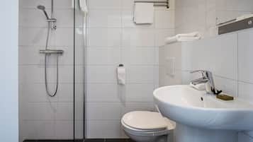 A modern bathroom with a glass shower enclosure, a white toilet, and a white sink with a soap dish.