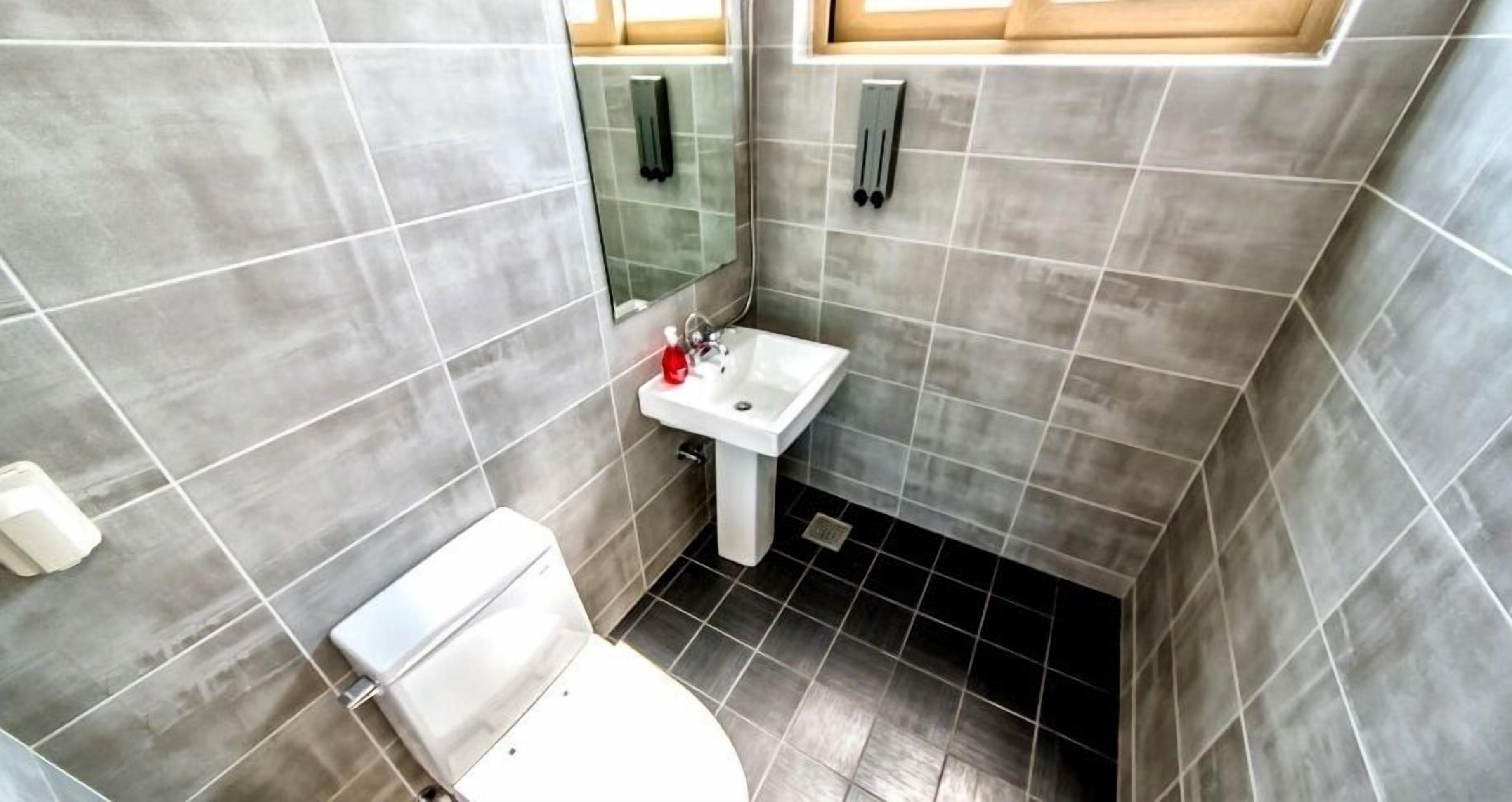 Un bagno piccolo con il water, lavandino e specchio.