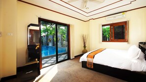 A hotel room with a bed, a view of a swimming pool, and a sliding glass door leading to an outdoor area. - Samui Sun Villa (Koh Samui)