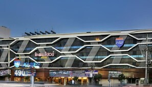 Un bâtiment moderne à la façade géométrique, doté de plusieurs niveaux et de grandes fenêtres.