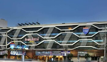 Un edificio moderno con fachada geométrica, que alberga varios espacios comerciales, incluyendo un hotel y una tienda 490.