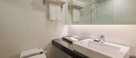 A modern bathroom with a large sink, towel racks, a shower, and a toilet.
