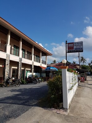 A hotel with a signboard advertising free WiFi and a contact number.