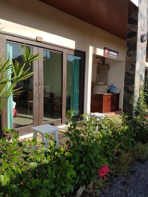 A hotel entrance with a reception desk, a signboard, and a glass door. - MM House Samui (Koh Samui)