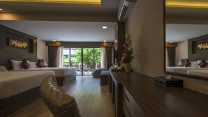 Une chambre d’hôtel avec deux lits, un bureau en bois et une grande fenêtre donnant sur l’extérieur.