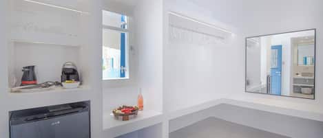 Un baño moderno y minimalista con lavavajillas integrado, un lavamanos pequeño y un espejo.