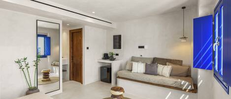 A modern living room with a sofa, coffee table, and a television mounted on the wall.