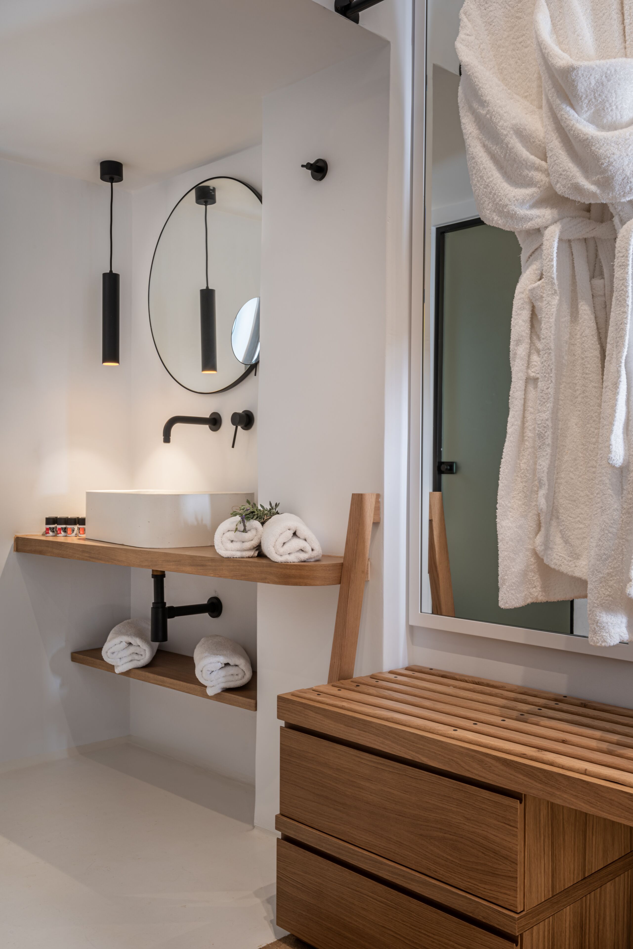 Une salle de bain moderne avec un meuble-lavabo en bois, un grand miroir et un porte-serviettes.