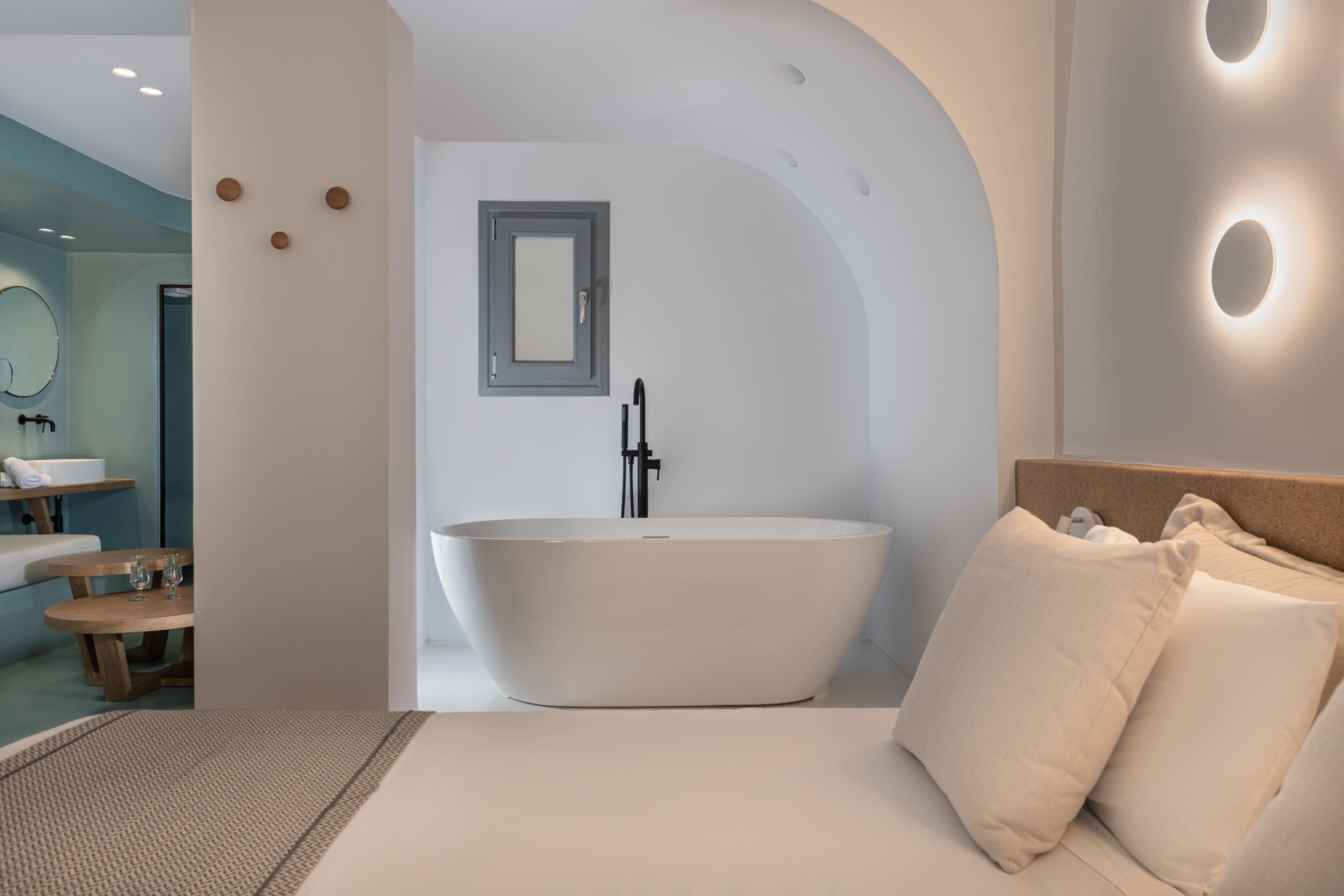 Une salle de bain moderne avec une baignoire sur pieds, un miroir et un meuble-lavabo en bois.