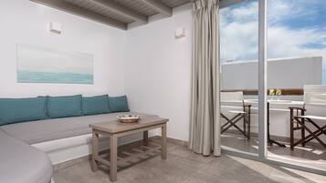 Una habitación moderna con sofá, una mesita y vistas al exterior.