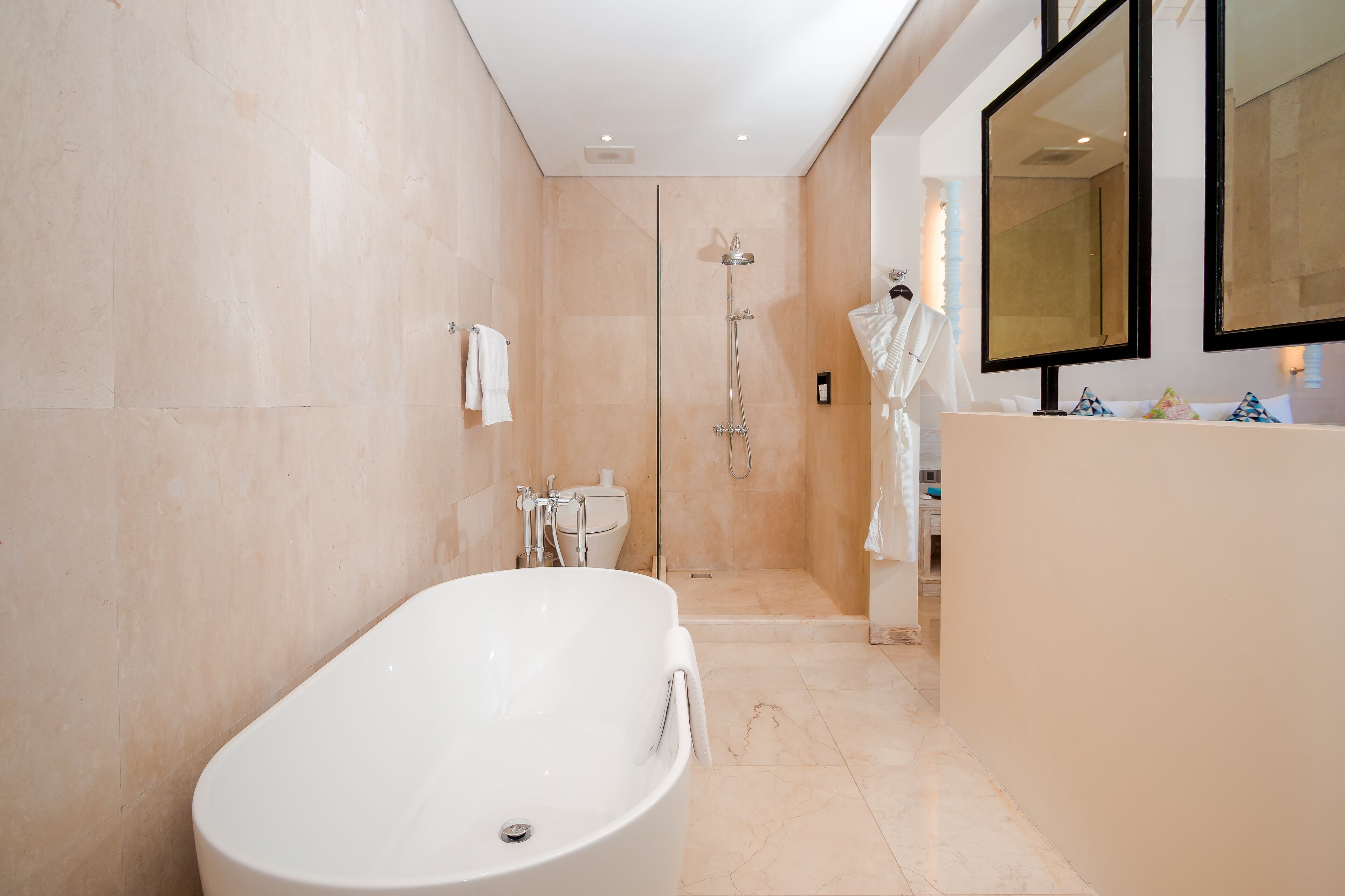 Ein modernes Badezimmer mit einer freistehenden Badewanne, einer begehbaren Dusche und einem großen Spiegel über dem Waschbecken.