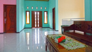 A spacious lobby with a polished floor, a wooden bench, and a table with a placemat.
