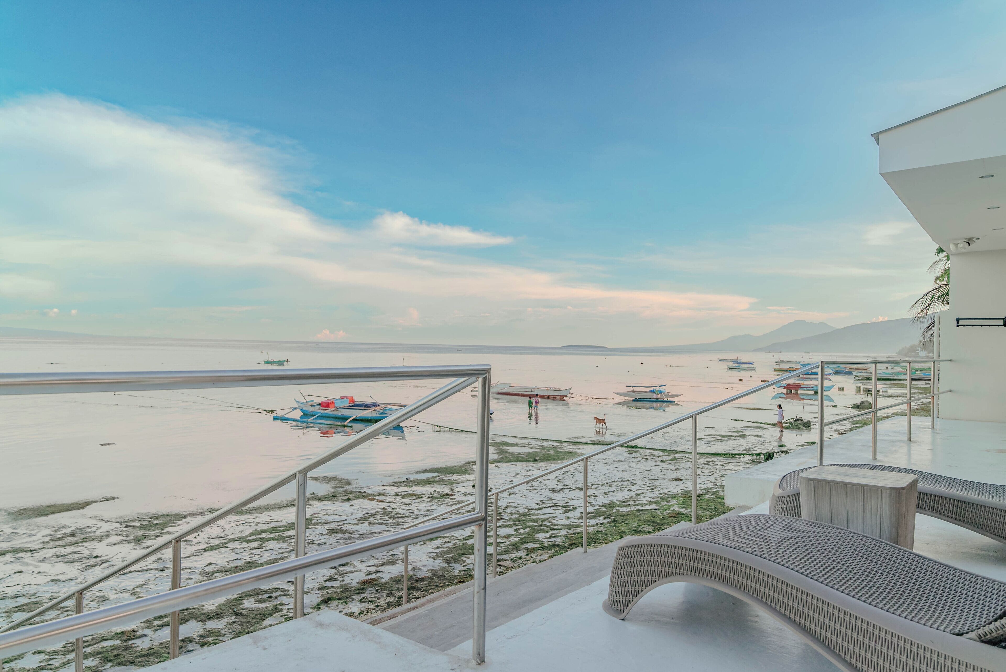 Une vue sur la plage depuis un balcon doté d’une balustrade, d’un escalier et d’un espace détente.