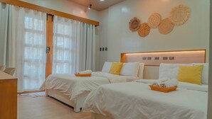 Une chambre d’hôtel avec deux lits, une tête de lit en bois et un luminaire fixé au mur.