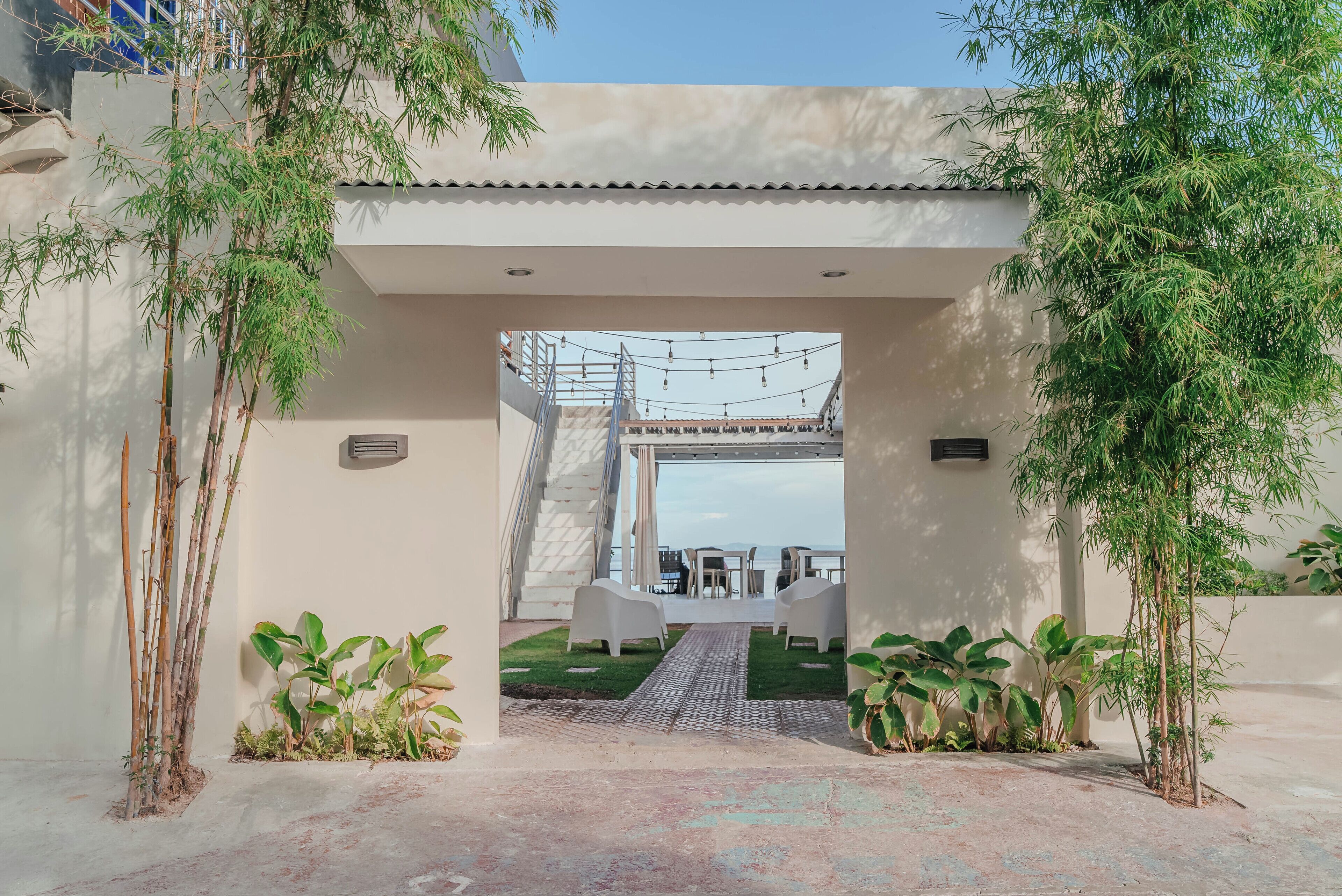 A modern entrance with a covered pathway leading to a seating area.
