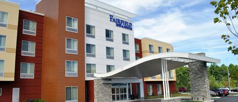 Un hotel Fairfield Inn & Suites con un diseño moderno, que cuenta con un acceso cubierto y varios pisos.