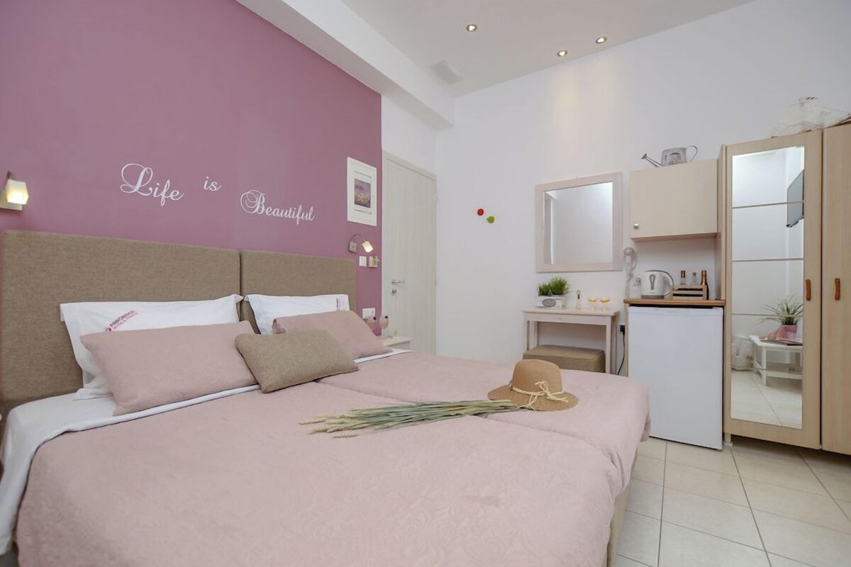 A bedroom with a bed, a dresser, a mirror, and a wall with a motivational quote.