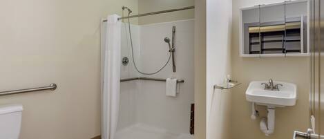 A bathroom with a shower, toilet, and sink.