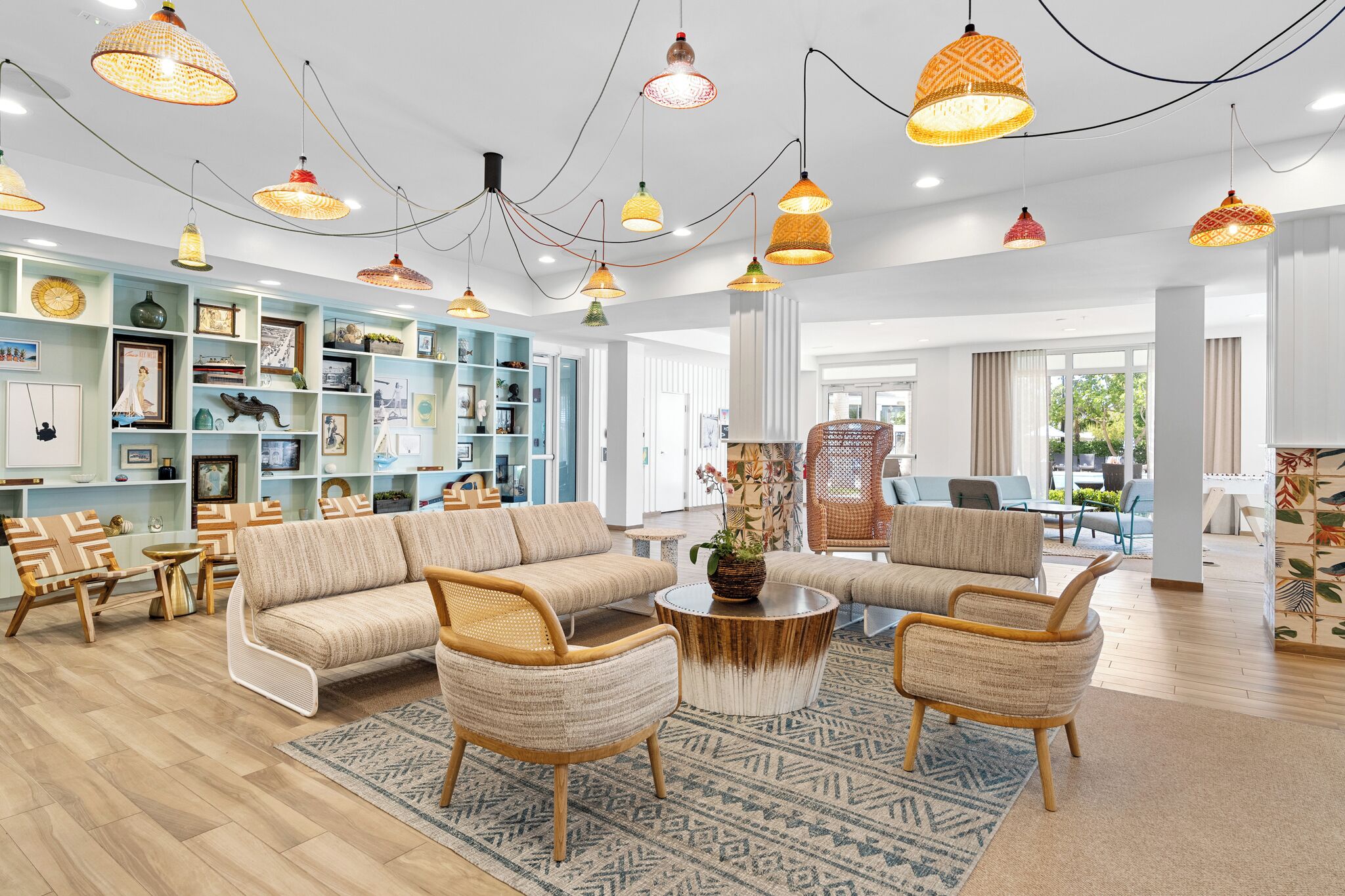 A spacious living room with a sofa, armchairs, and a coffee table, featuring a bookshelf and decorative items.