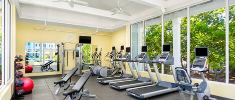 A gym with treadmills, exercise balls, and a mirror.
