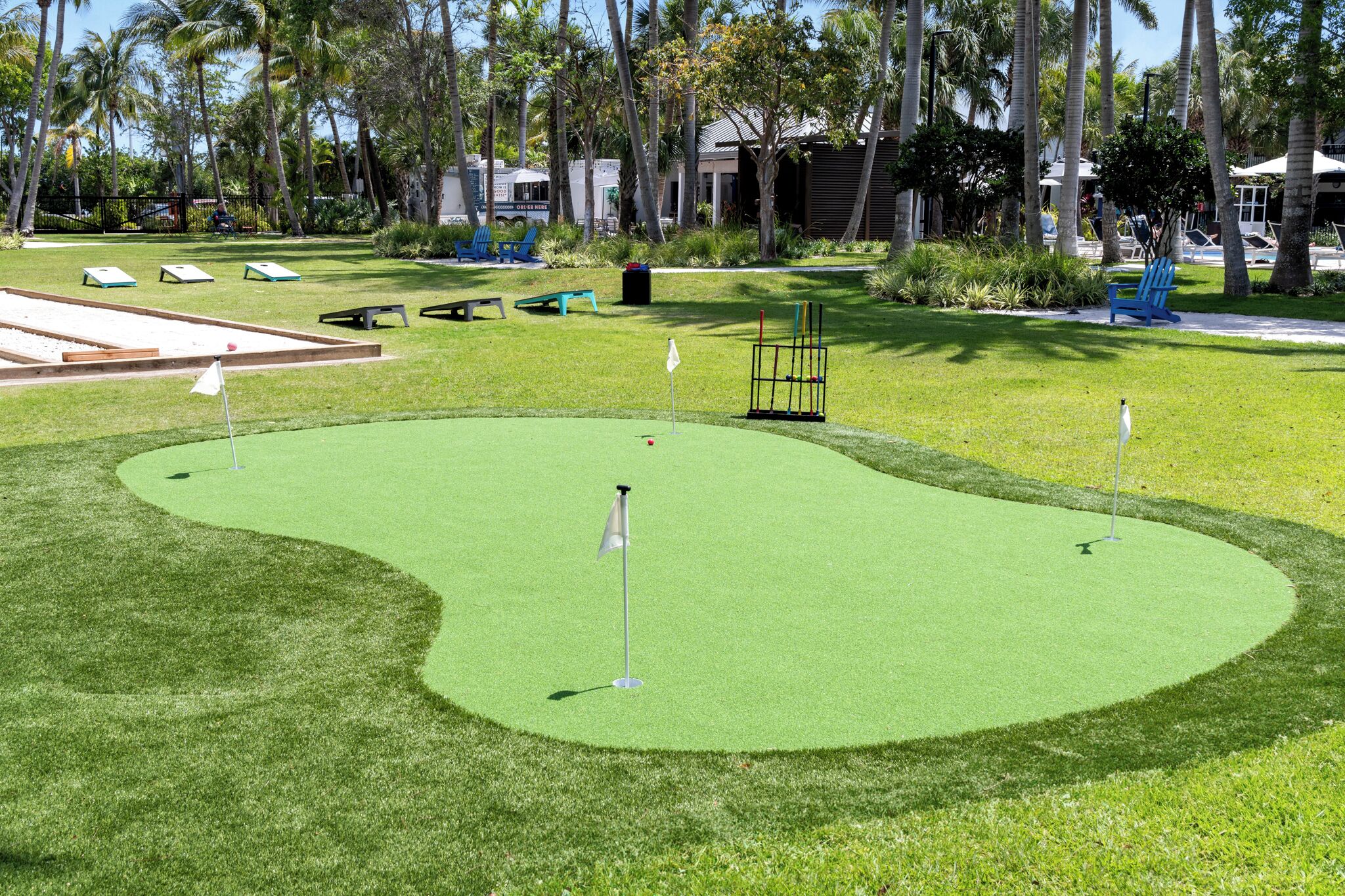 A golf course with a putting green, sand bunkers, and a flagstick.